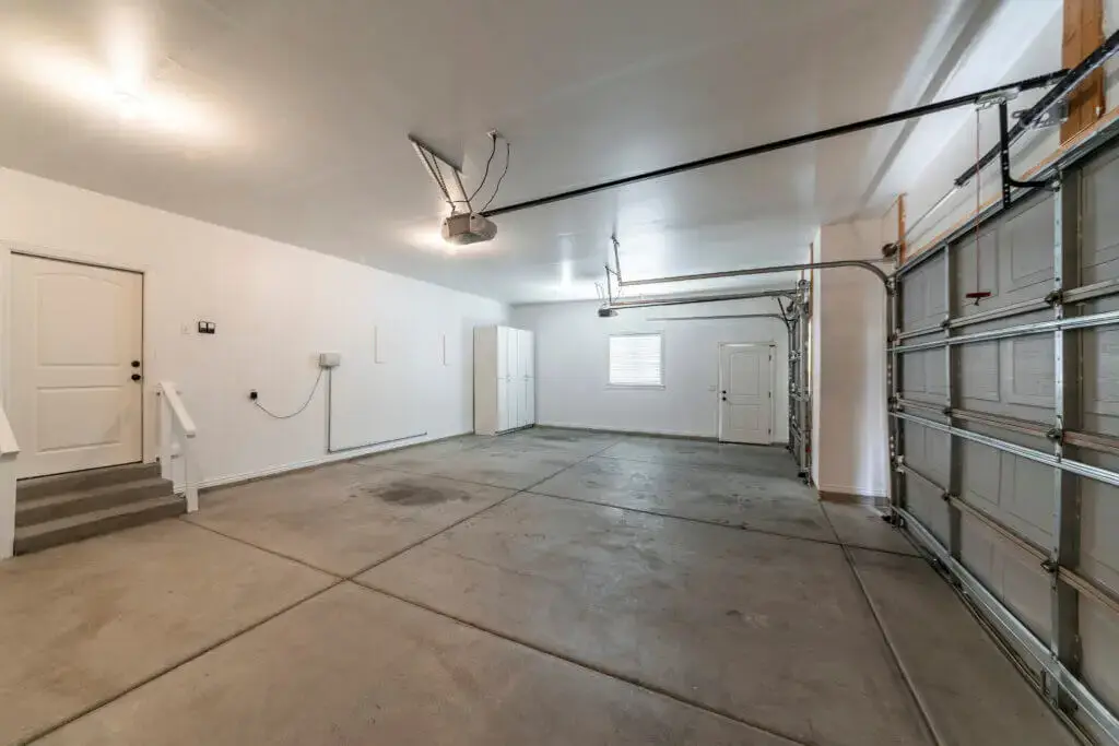 A large empty garage with a garage door