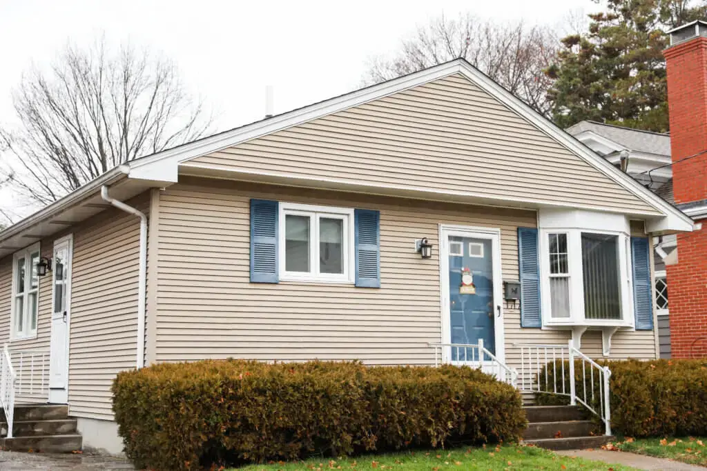 A house with a blue door and a white railing